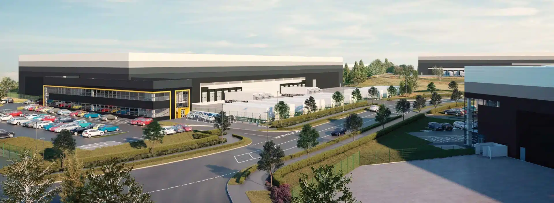 Modern industrial building with car park and greenery.