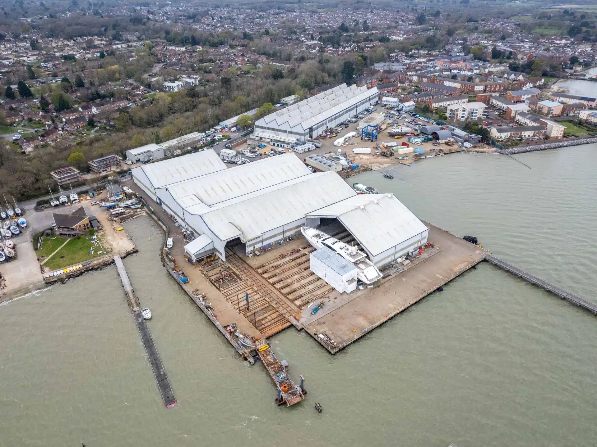 Aerial view of a large shipyard by the coast.