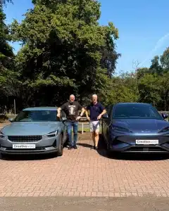 Two men stand between Polestar and BYD electric cars