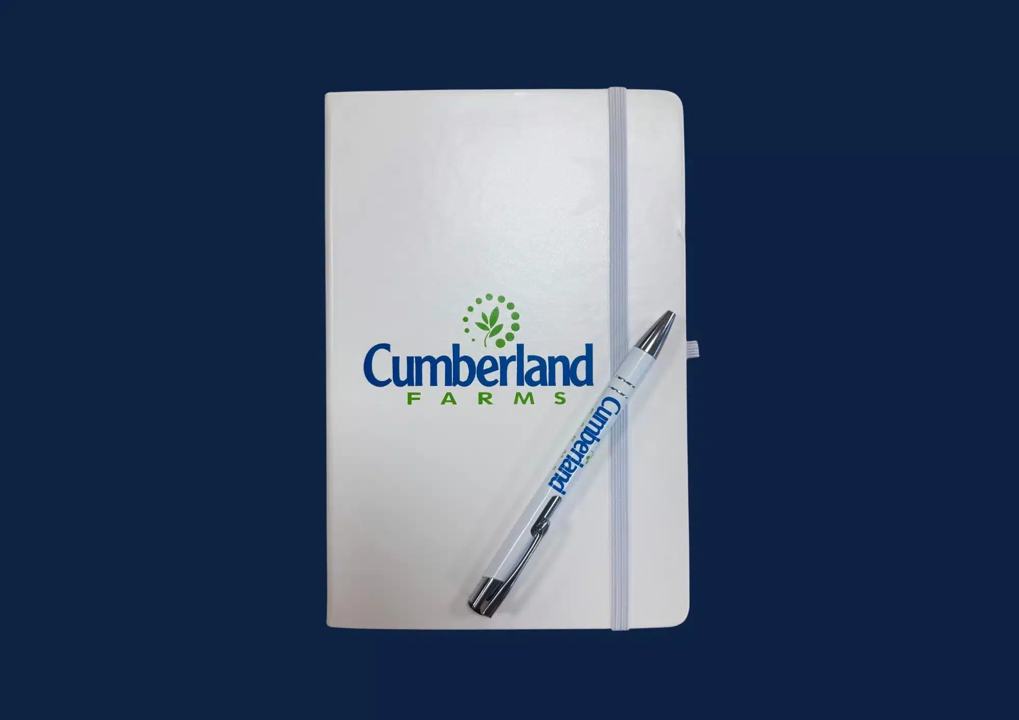 Cumberland Farms branded notebook and pen on navy background