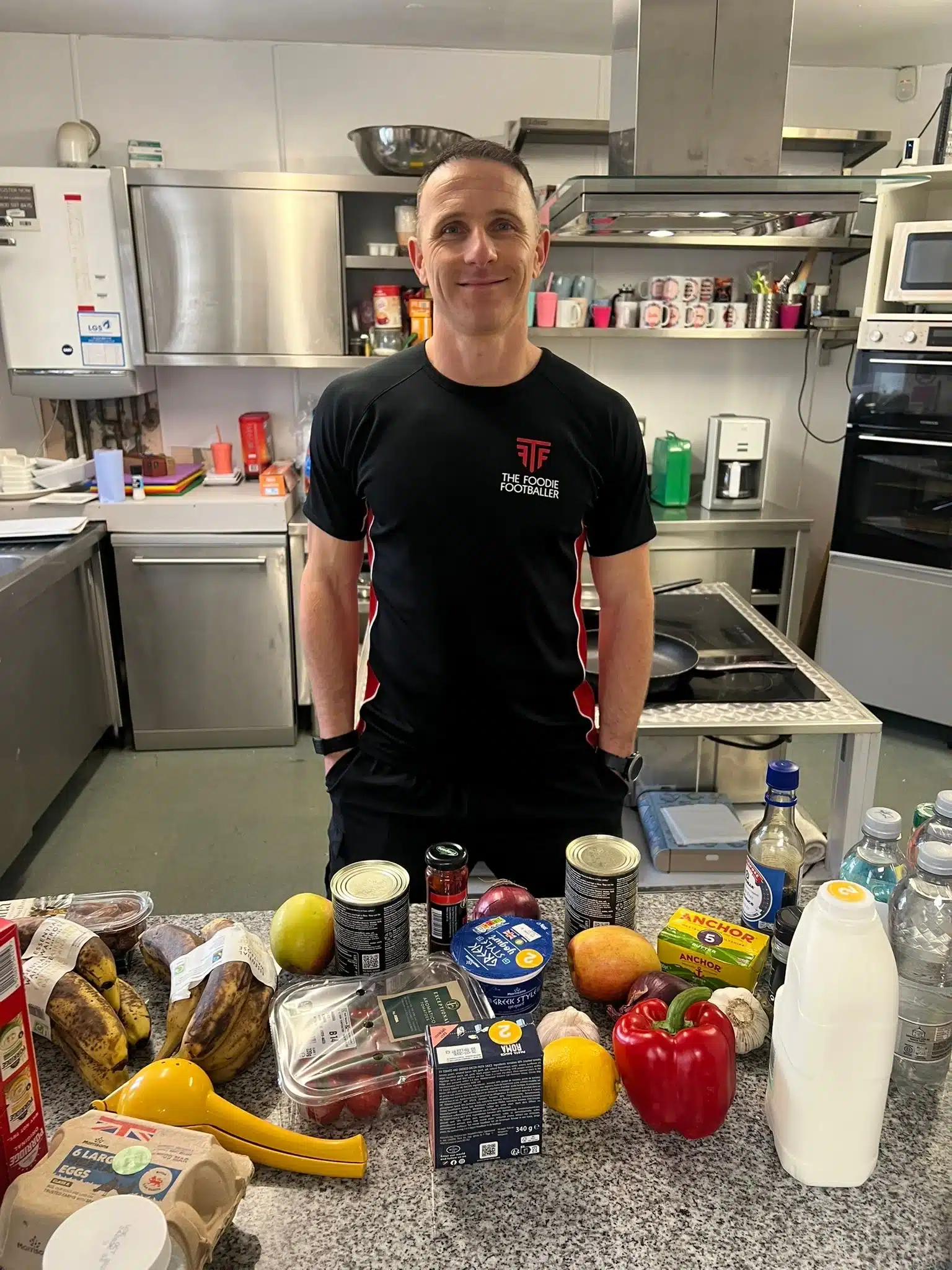 Man standing behind fresh groceries in commercial kitchen