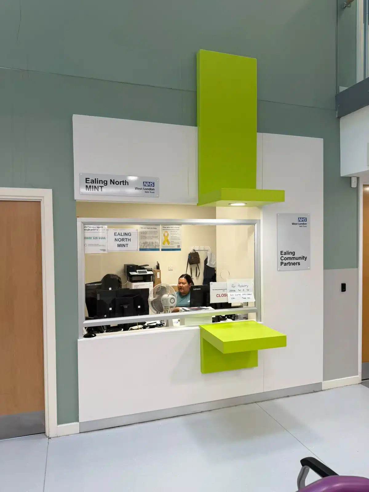Ealing North MINT NHS reception desk with lime-green signage