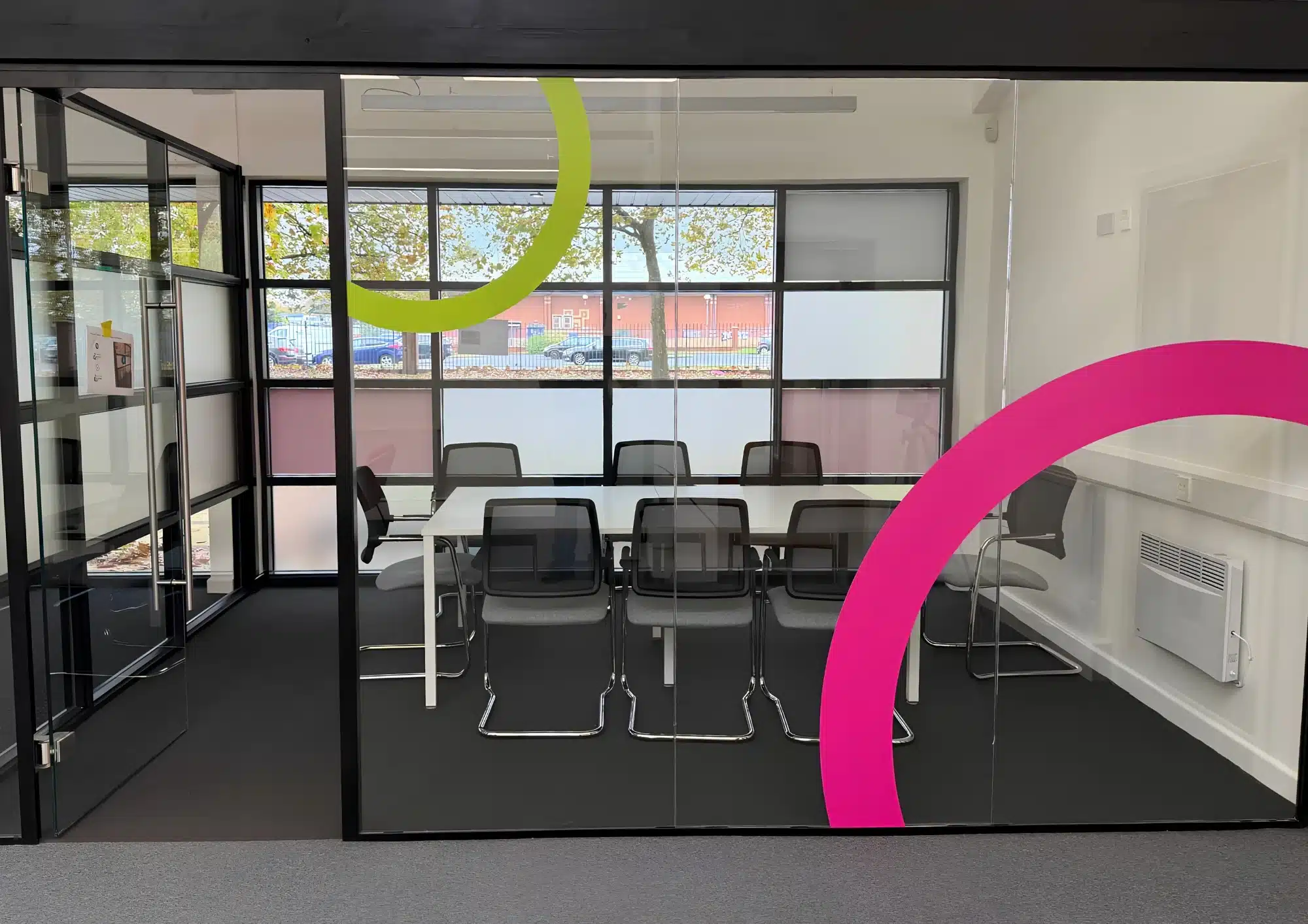 Modern glass meeting room with colourful curved decals